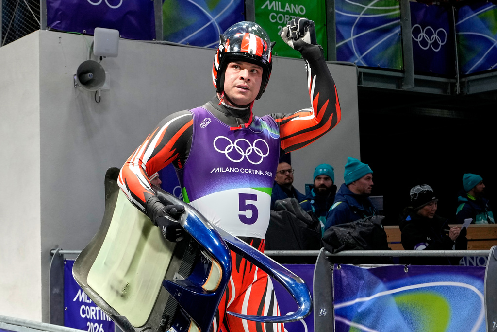 Austria's Jonas Mueller raises a fist after a men's single luge run at the 2026 Winter Olympics, in Cortina d'Ampezzo, Italy, Saturday, Feb. 7, 2026. (AP Photo/Aijaz Rahi)