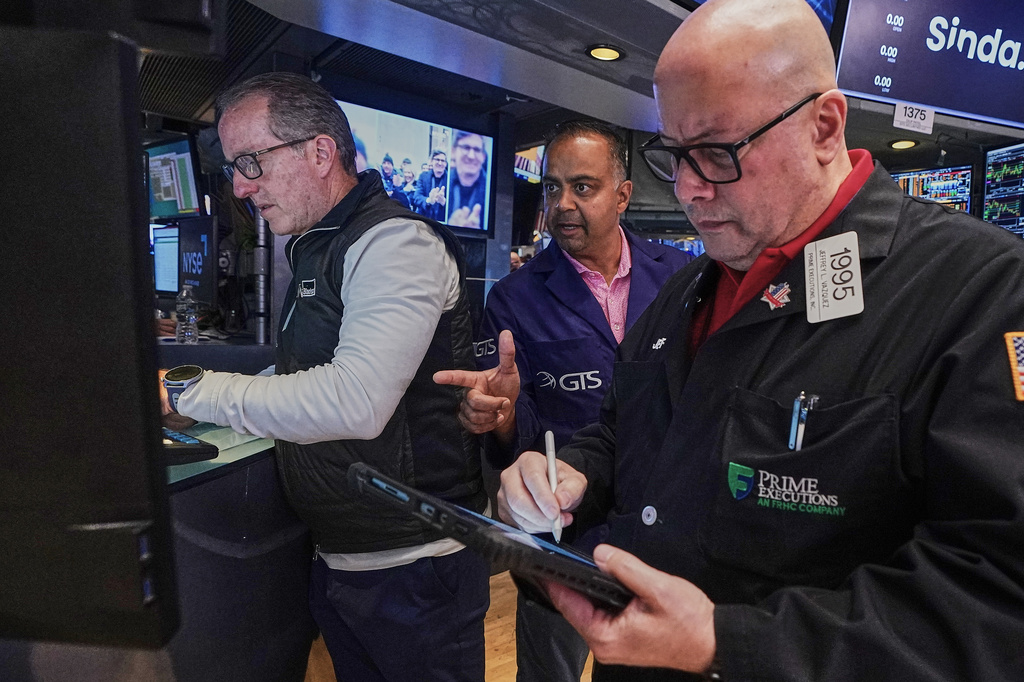 Specialist Glenn Carell, left, and Dilip Patel, center, work with trader Jeffrey Vazquez on the floor of the New York Stock Exchange, Friday, June 26, 2026. (AP Photo/Richard Drew)