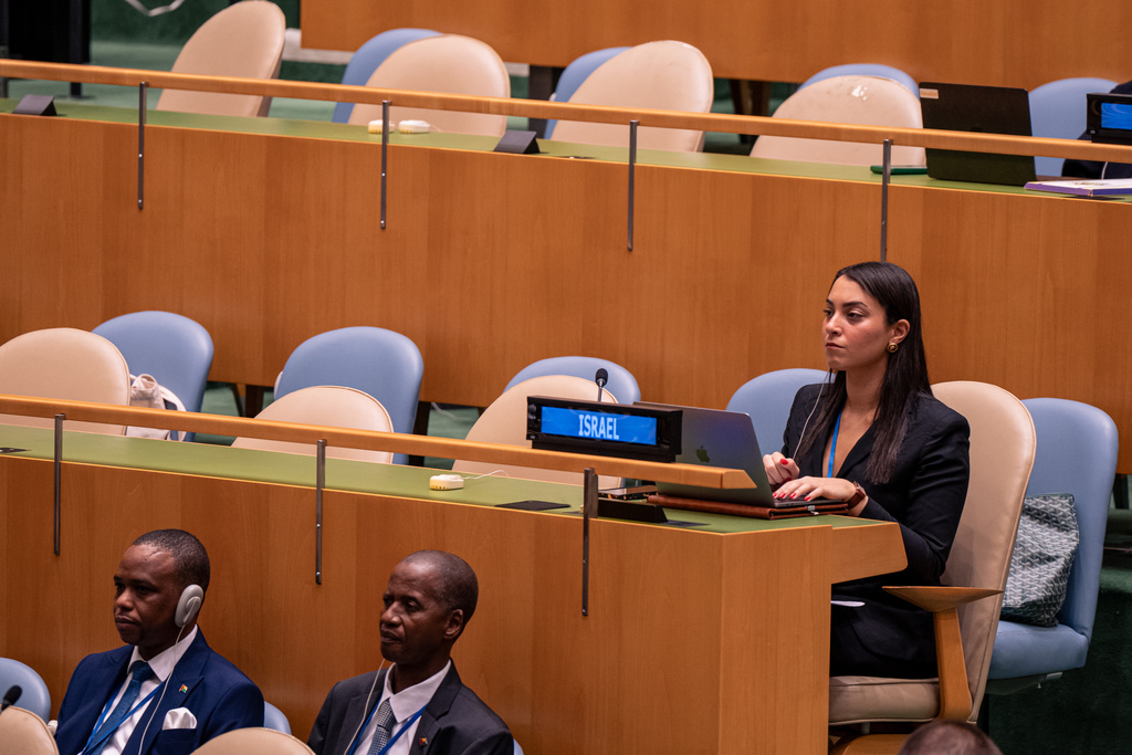 A woman from the delegation of Israel watches Palestinian President Mahmoud Abbas address the 80th session of the United Nations General Assembly via video at United Nations headquarters, Thursday, Sept. 25, 2025. (AP Photo/Angelina Katsanis)