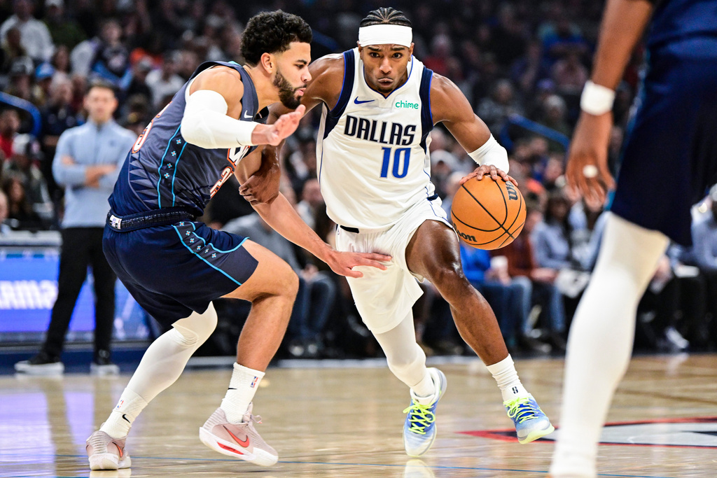 Dallas Mavericks guard Brandon Williams (10) drives against Oklahoma City Thunder guard Ajay Mitchell (25) during the first half of an NBA basketball game, Friday, Dec. 5, 2025, in Oklahoma City. (AP Photo/Gerald Leong)