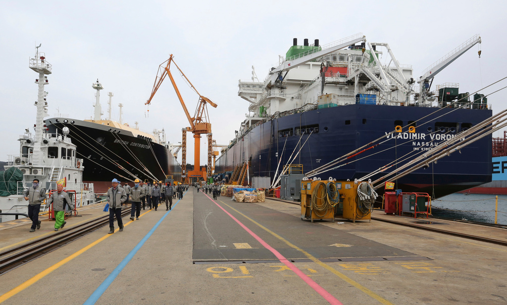 FILE - Workers walk past large-sized liquefied natural gas (LNG) carriers under construction at the Daewoo Shipbuilding and Marine Engineering facility in Geoje Island, South Korea, Dec. 7, 2018. (AP Photo/Ahn Young-joon, File)