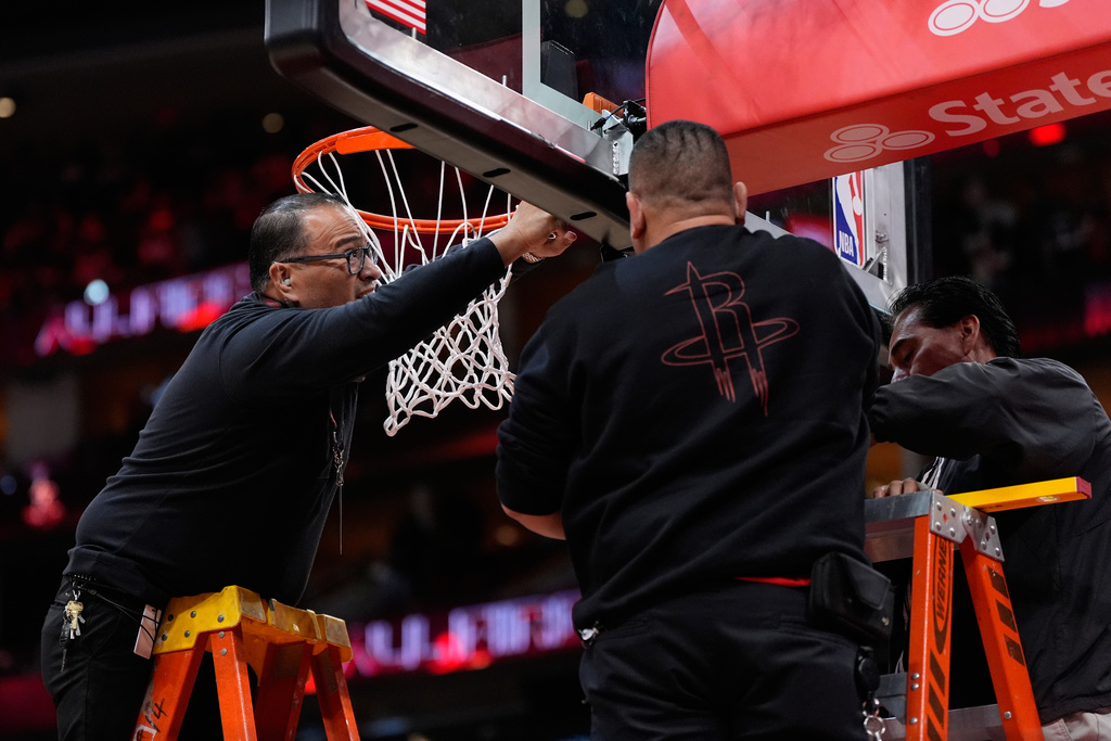 Crews replace a damaged hoop before an NBA basketball game between the San Antonio Spurs and the Houston Rockets in Houston, Tuesday, Jan. 20, 2026. (AP Photo/Ashley Landis)