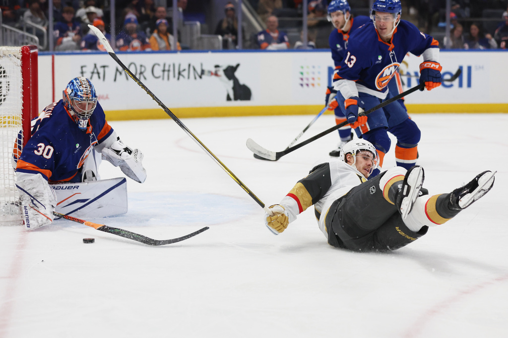 New York Islanders goaltender Ilya Sorokin (30) is called for a penalty for tripping Vegas Golden Knights' Brett Howden, right, during the first period of an NHL hockey game, Tuesday, Dec. 9, 2025, in Elmont, N.Y. (AP Photo/Heather Khalifa)