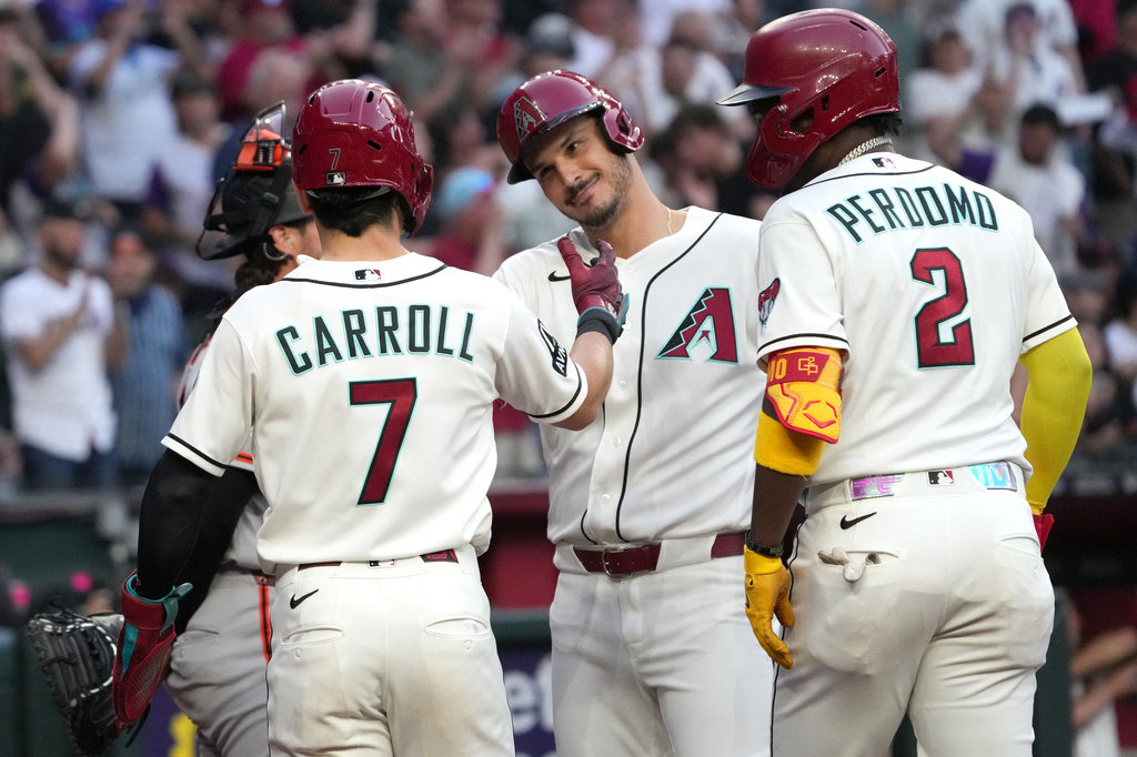 Arizona Diamondbacks' Nolan Arenado, second from right, celebrates with Corbin Carroll (7) and Geraldo Perdomo (2) after hitting a grand slam against the San Francisco Giants in the first inning of a baseball game, Monday, May 18, 2026, in Phoenix. (AP Photo/Rick Scuteri)