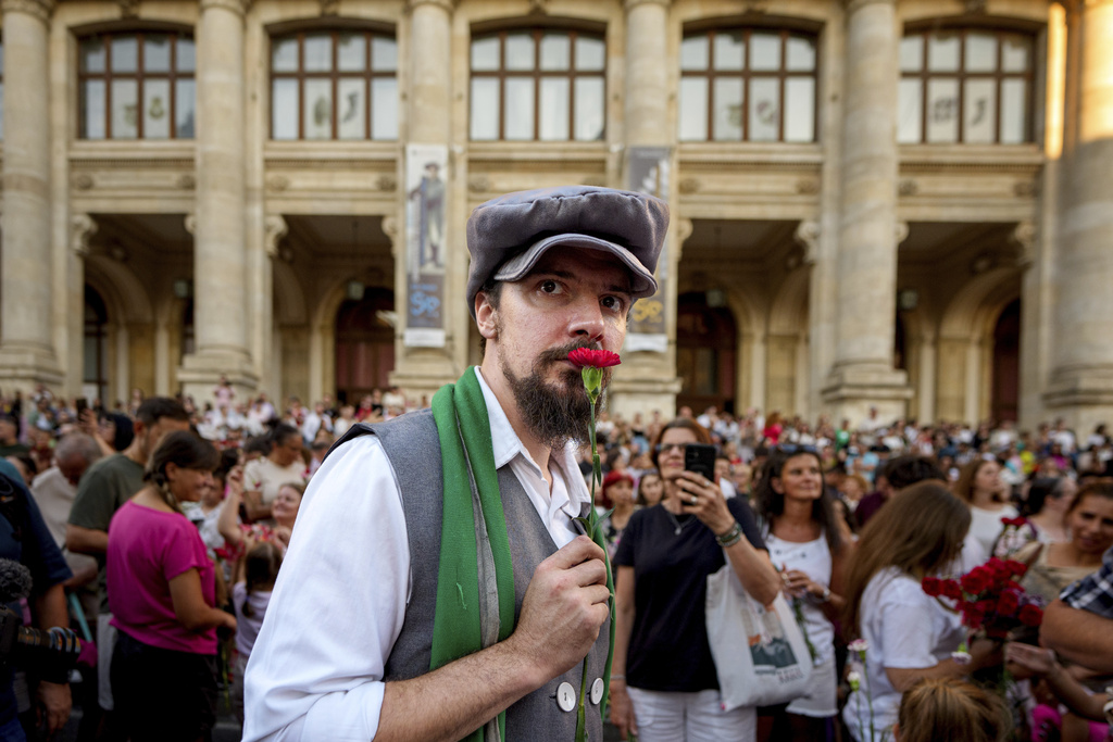 A man wearing vintage styled outfit holds a carnation during an event marking the day when the Romanian capital was first mentioned in historical records, 566 years ago, in Bucharest, Romania, Saturday, Sept. 20, 2025. (AP Photo/Andreea Alexandru)