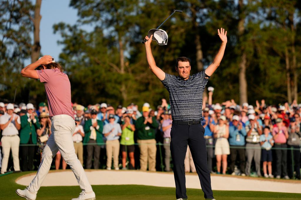 FILE - Cameron Smith, of Australia, walks past as Scottie Scheffler celebrates after winning the 86th Masters golf tournament on April 10, 2022, in Augusta, Ga. (AP Photo/Matt Slocum, File)