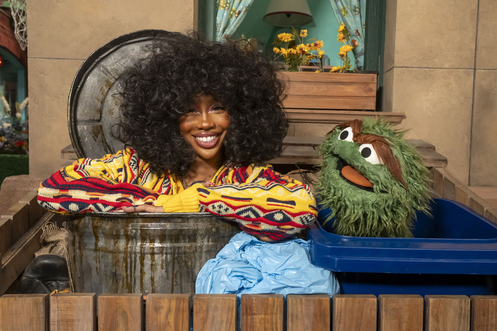 This image released by Sesame Workshop shows singer SZA, left, with muppet character Oscar the Grouch on the set of "Sesame Street." (Richard Termine/Sesame Workshop via AP)