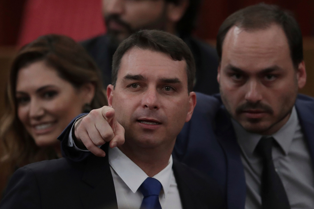 FILE - Flavio Bosonaro, center, and Carlos Bolsonaro, sons of Brazil's President-elect Jair Bolsonaro, attend a ceremony officially confirming the presidential elections results which their dad won at the Supreme Electoral Court in Brasilia Brazil, Dec. 10, 2018. (AP Photo/Eraldo Peres, File)