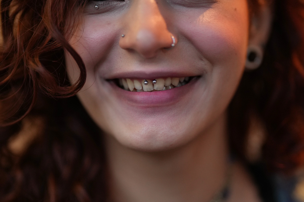 Kiana, no surname given, poses for a photo as she drinks a hot beverage at a café in central Tehran, Iran, Wednesday, April 8, 2026. (AP Photo/Francisco Seco)