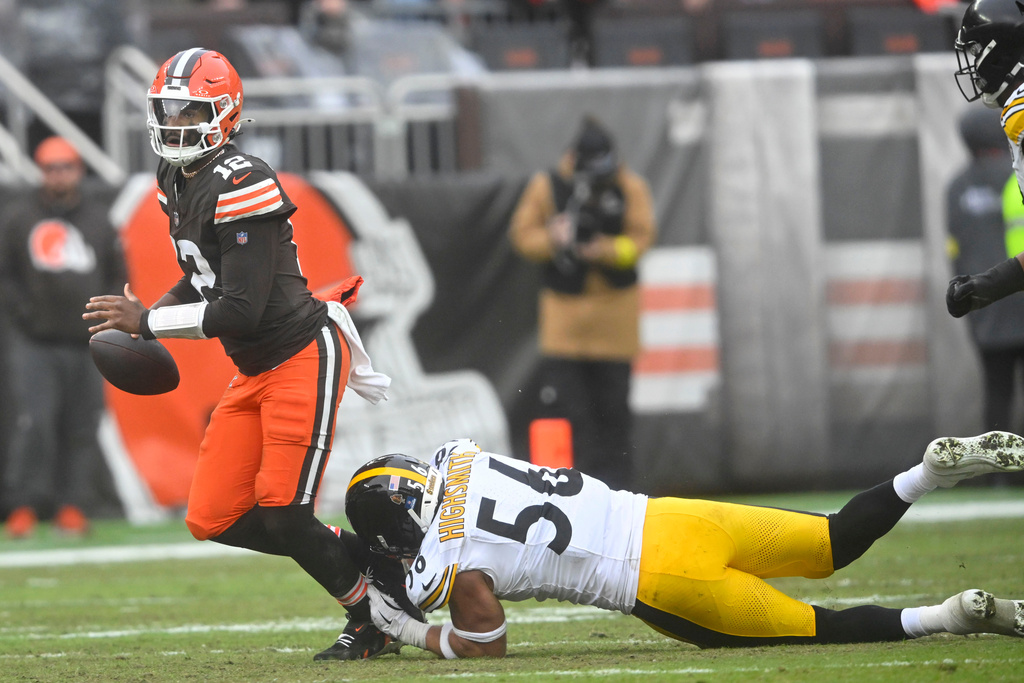Cleveland Browns quarterback Shedeur Sanders (12) tries to break a tackle by Pittsburgh Steelers linebacker Alex Highsmith (56) during the second half of an NFL football game, Sunday, Dec. 28, 2025, in Cleveland. (AP Photo/David Richard)
