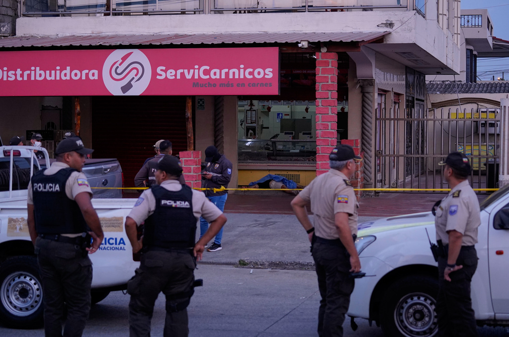Police work the scene as the body of slain soccer player Mario Pineida lies on the floor at a butcher shop in Guayaquil, Ecuador, Wednesday, Dec. 17, 2025. (AP Photo/Cesar Munoz)