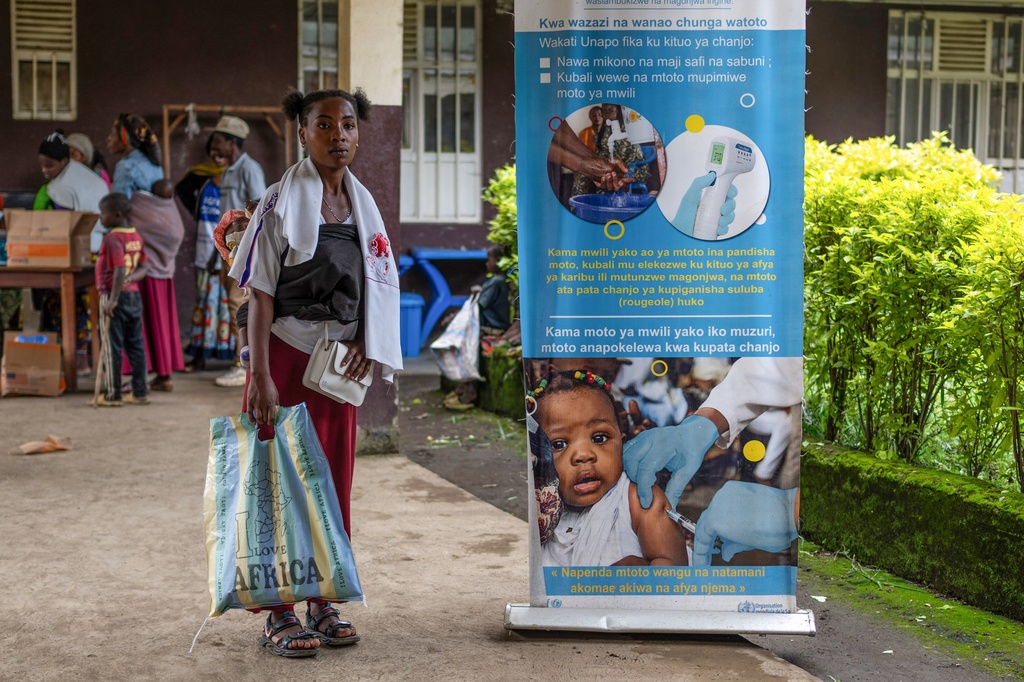 A woman brings her child for a measles vaccination at the Kachehembe health center, in Rubaya, eastern Democratic Republic of Congo, Monday, Dec. 1, 2025. (AP Photo/Moses Sawasawa)
