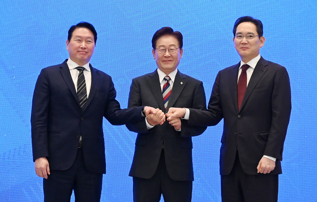 South Korean President Lee Jae Myung, center, holds hands with Samsung Electronics Chairman Lee Jae-yong, right, and SK Group Chairman Chey Tae-won after an announcement of building a new computer chipmaking hub, as they meet at the Blue House presidential office in Seoul, South Korea, Monday, June 29, 2026. (Kim Min-Hee/Pool Photo via AP)