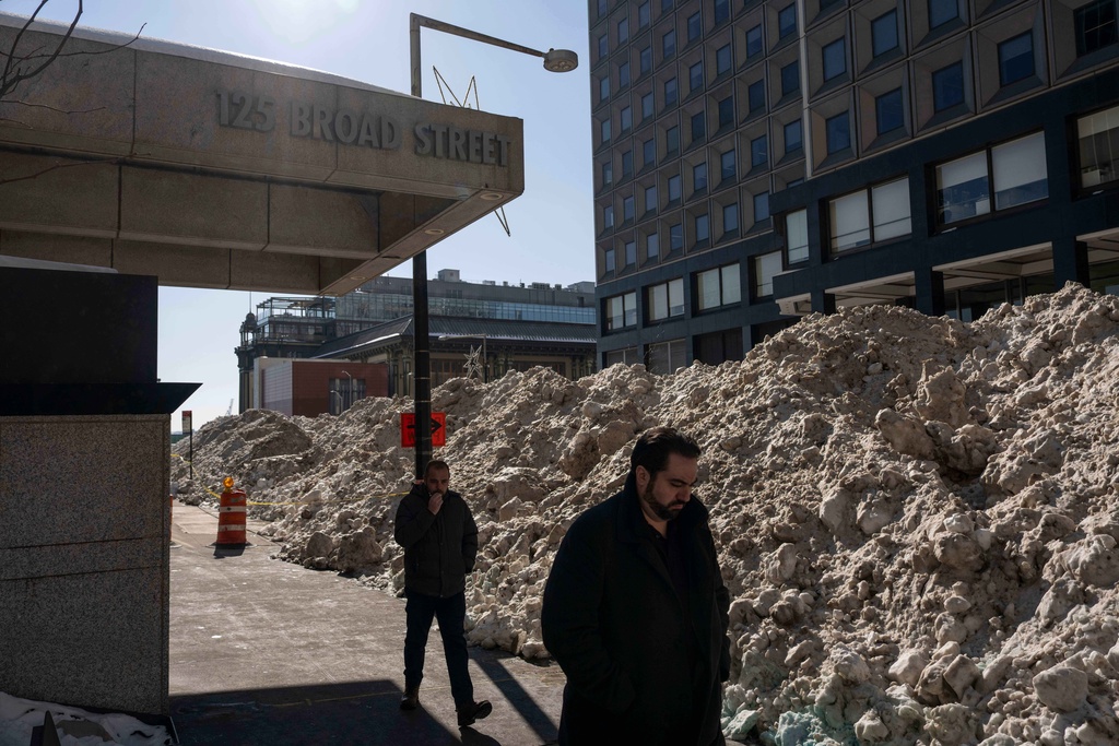 Pedestrians walk past a pile of snow during a Department of Sanitation snow melting operation in New York City, Thursday, Jan. 29, 2026. (AP Photo/Yuki Iwamura)