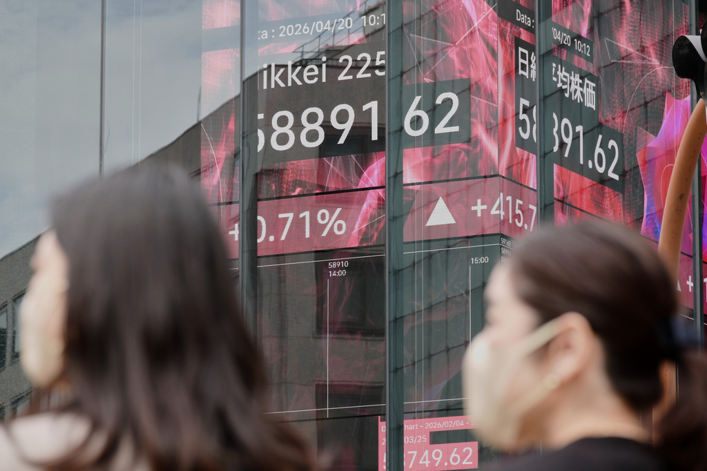 People stand in front of an electronic stock board showing Japan's Nikkei index at a securities firm Monday, April 20, 2026, in Tokyo. (AP Photo/Eugene Hoshiko)