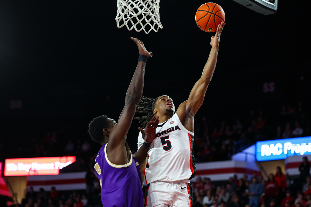 Georgia guard Jeremiah Wilkinson (5) shoots over Western Carolina center Abdulai Fanta Kabba, left, during the first half of an NCAA college basketball game, Thursday, Dec. 18, 2025, in Athens, Ga. (AP Photo/Colin Hubbard)