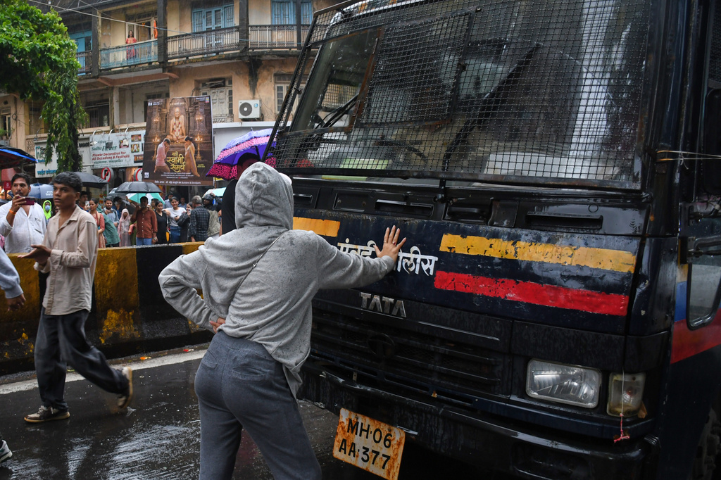 Rhiya Ahir, a model, blocks a police van carrying detained protesters during a demonstration demanding educational reforms as part of the Cockroach Janta Party's ongoing protest movement in Mumbai, India, Wednesday, July 22, 2026. (AP Photo/Ashish Vaishnav)