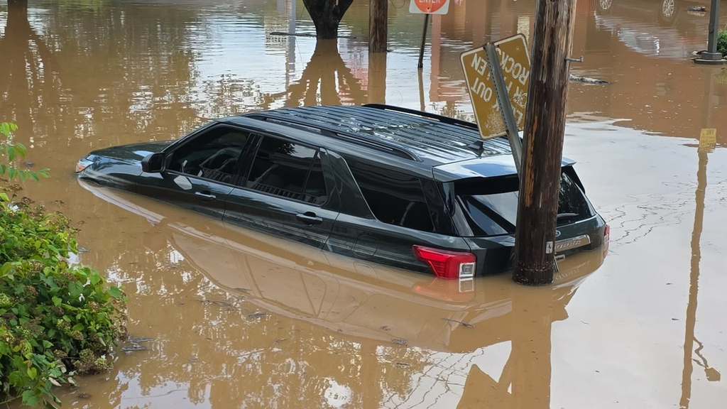 A vehicle sits half-submerged in floodwaters in Buckhannon, W.Va., on Wednesday, July 22, 2026. (Evan Bacorn/via AP). CORRECTS PHOTOGRAPHER NAME TO EVAN BACORN FROM EVAN ACORN