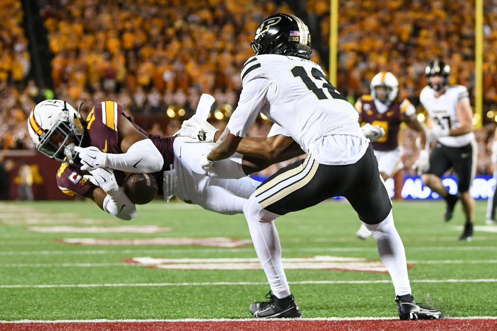 Minnesota defensive back Kerry Brown, left, intercepts a pass intended for Purdue wide receiver Corey Smith (12) during the first half of an NCAA college football game on Saturday, Oct. 11, 2025, in Minneapolis. (AP Photo/Craig Lassig)