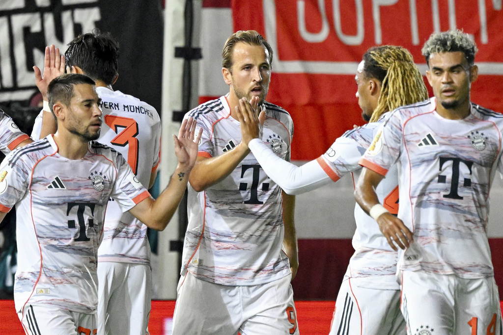 Bayern Munich's Harry Kane, center, is congratulated after scoring from the penalty spot against SV Wehen Wiesbaden during the DFB Pokal, Germany Cup, soccer match, Wednesday, Aug 27, 2025, in Wiesbaden, Germany. (Uwe Anspach/dpa via AP)