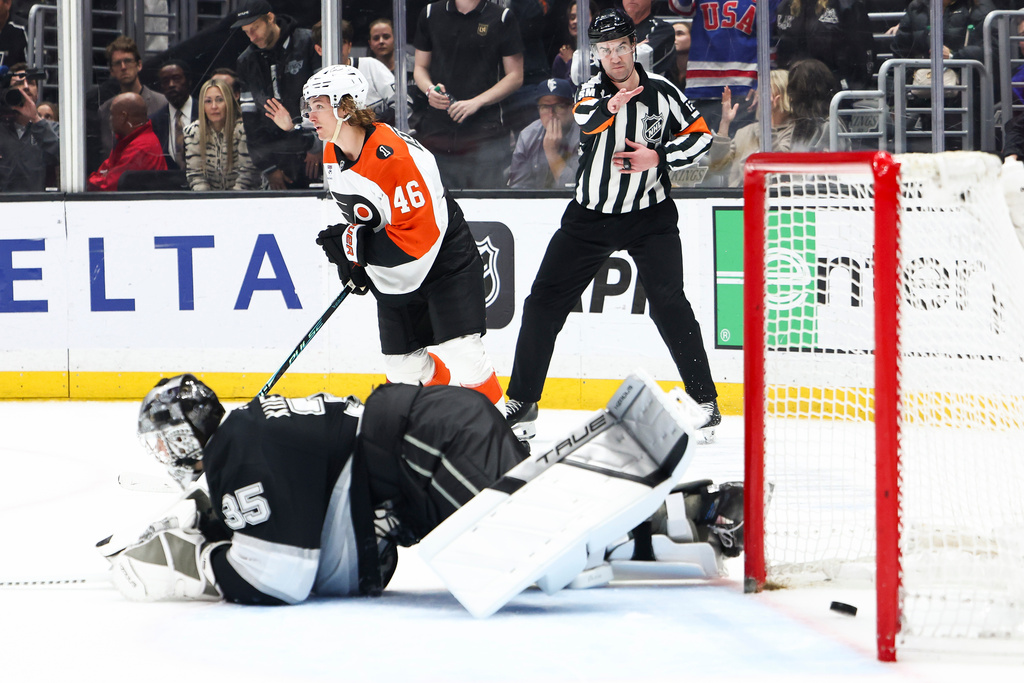 Philadelphia Flyers center Trevor Zegras (46) skates after scoring a goal as Los Angeles Kings goaltender Darcy Kuemper (35) looks on from the ice and referee Cody Beach, back right, gestures during a shootout of an NHL hockey game, Thursday, March 19, 2026, in Los Angeles. (AP Photo/Jessie Alcheh)