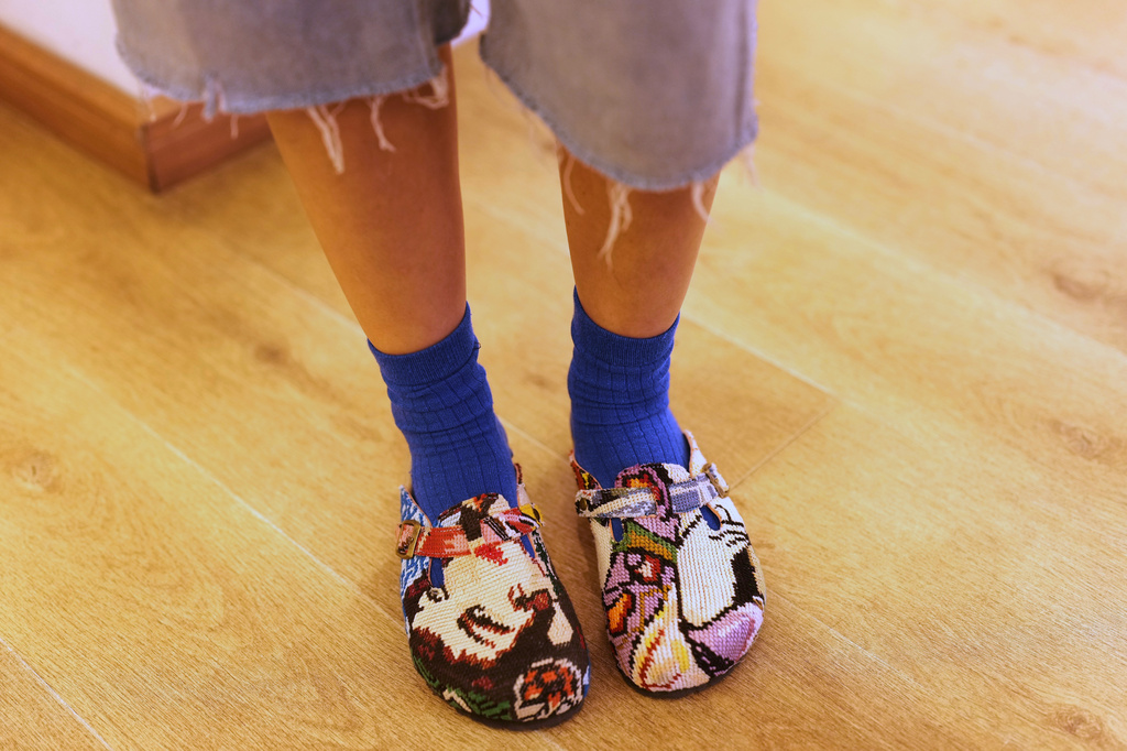 A customers poses for a photo of her shoes while browsing at a gift shop, in central Tehran, Iran, Wednesday, April 8, 2026. (AP Photo/Francisco Seco)