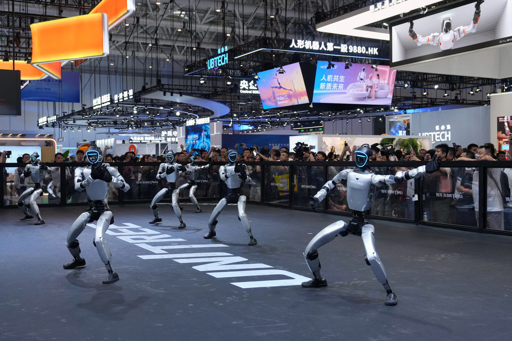 Visitors watch robots perform at a booth of Unitree, one of China's largest humanoid robot makers, during the World Robot Conference at the Beijing Yichuang International Convention and Exhibition Centre in Beijing, Wednesday, Aug. 19, 2026. (AP Photo/Andy Wong)