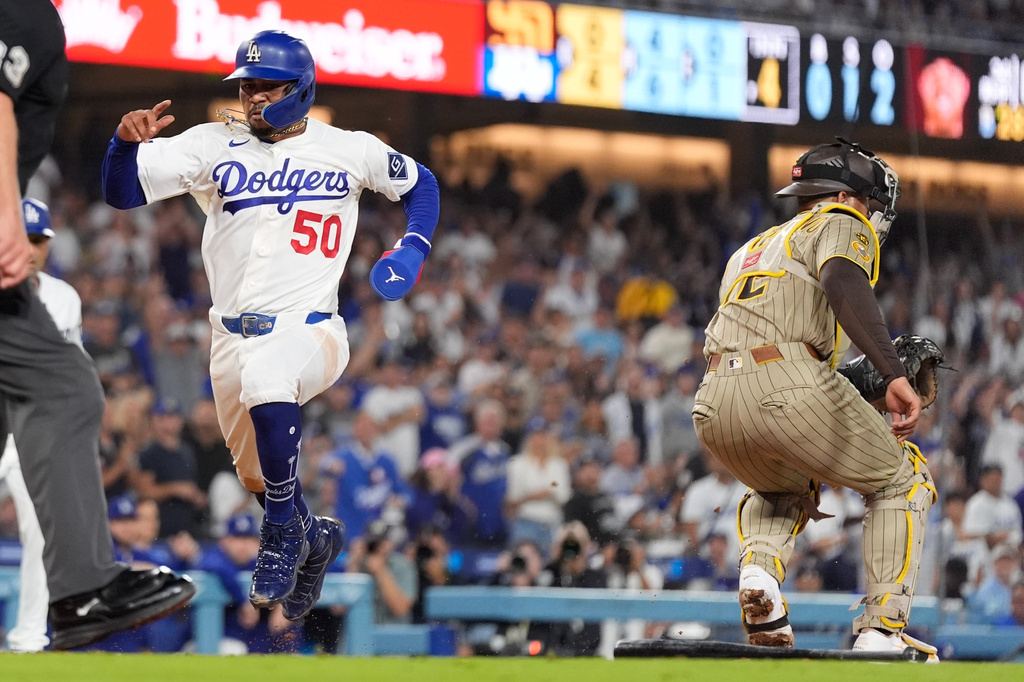 Los Angeles Dodgers' Mookie Betts, left, scores on a single by Freddie Freeman as San Diego Padres catcher Luis Campusano takes a late throw during the fifth inning of a baseball game Tuesday, Sept. 22, 2026, in Los Angeles. (AP Photo/Mark J. Terrill)