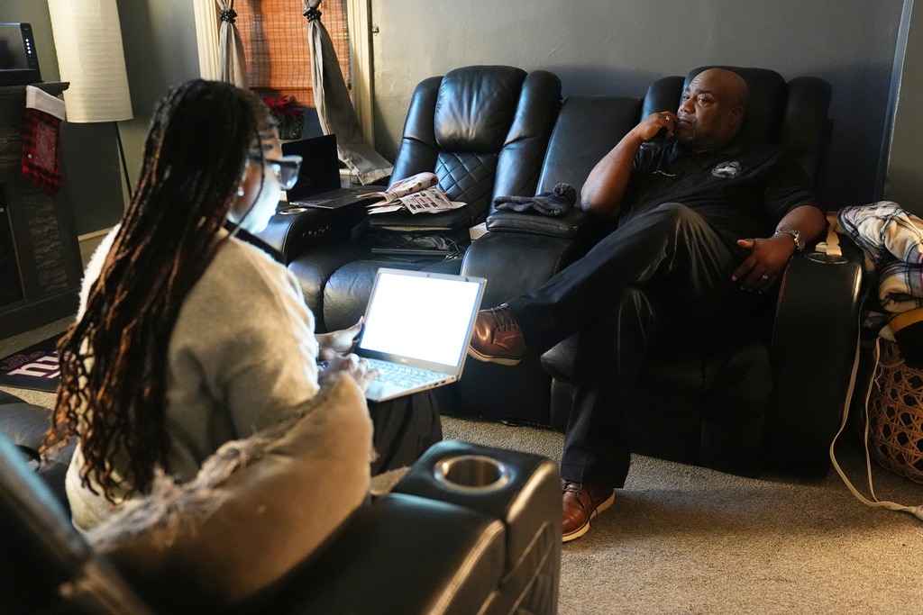 Ahmad Collins watches television accompanied by his wife Nickey at their home in Harrisburg, Pa., Thursday, Dec. 11, 2025. Ahmad Collins works at his office in Harrisburg, Pa., Thursday, Dec. 11, 2025. A city government worker and former Penn State linebacker, Collins has needed 10 hours a night of dialysis since a medical procedure left him with damaged kidneys late last year. (AP Photo/Matt Rourke)