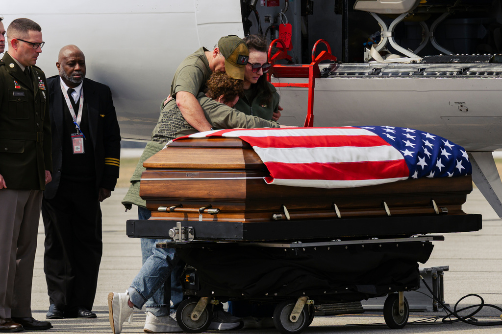 Family members stand with the casket carrying the remains of Army Sgt. Benjamin N. Pennington, 26, of Glendale, Ky., at Godman Army Airfield in Fort Knox, Ky., on Friday, March 20, 2026. (AP Photo/Jon Cherry)