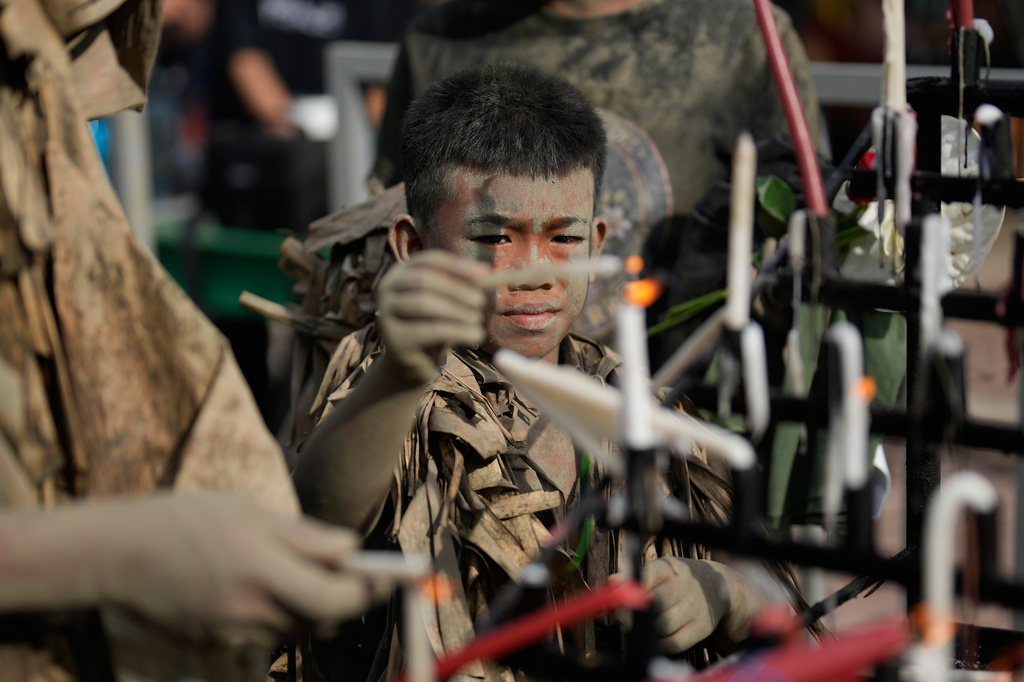 Catholic devotee Marcus Miel Neuda covered in mud and dried banana leaves participate at the mud people festival on the feast day of Saint John the Baptist at Bibiclat, Nueva Ecija province, northern Philippines on Wednesday, June 24, 2026. (AP Photo/Aaron Favila)