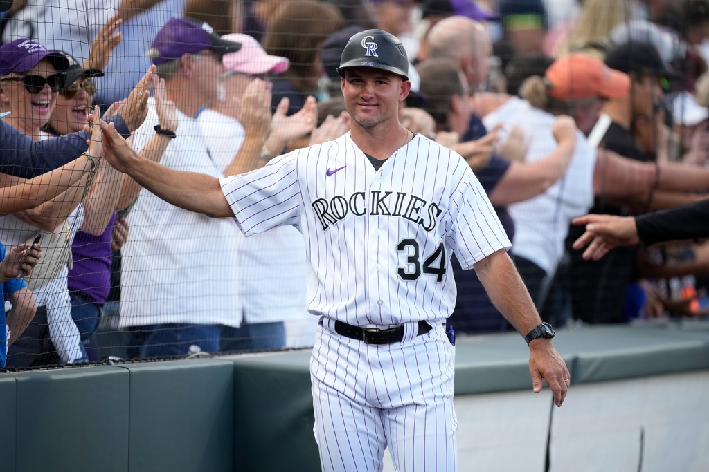 FILE - Colorado Rockies third base coach/infield coach Warren Schaeffer (34) greets fans during the team's ceremonial walk about the stadium after a baseball game, Oct. 1, 2023, in Denver. (AP Photo/David Zalubowski, File)