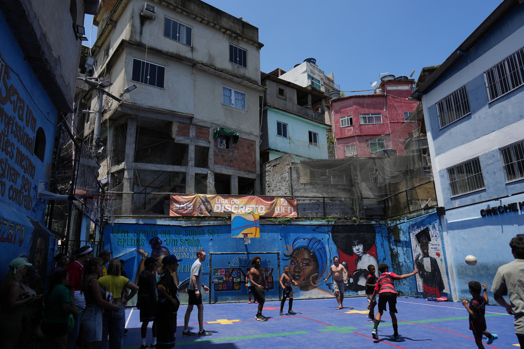 Tourists play soccer with residents of the Rocinha favela, as Rio de Janeiro recorded a record number of international tourists in 2025, Tuesday, Jan. 27, 2026. (AP Photo/Silvia Izquierdo)
