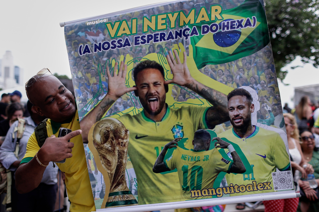 A fan poses with a poster of Brazilian soccer player Neymar, reading in Portuguese "Go Neymar, our hope for a sixth World Cup title" before Brazil's 2026 World Cup squad is announced, in Rio de Janeiro, Monday, May 18, 2026. (AP Photo/Bruna Prado)