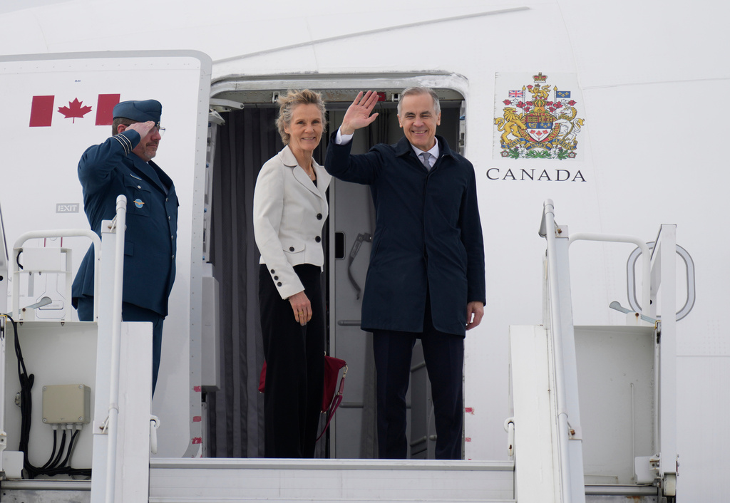 Prime Minister Mark Carney and Diana Fox Carney board a government plane in Ottawa on Thursday, Feb. 26, 2026. (Adrian Wyld/The Canadian Press via AP)