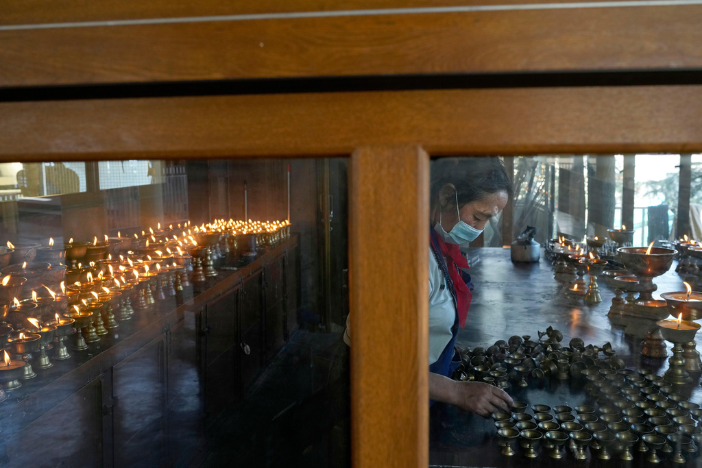 A Tibetan nun cleans copper lamps at Tsuglakhang temple in Mcleodganj near Dharamshala, India, March 6, 2025. (AP Photo/Manish Swarup)
