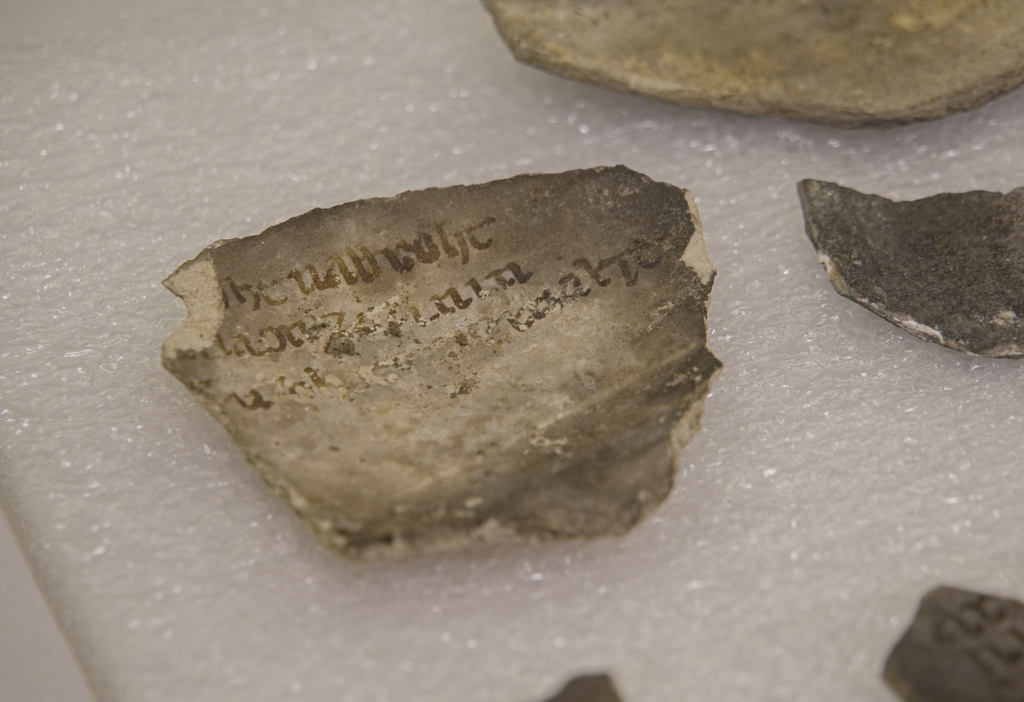 A fragment bearing an inscription is photographed among artifacts discovered during excavations outside Notre-Dame Cathedral in Paris, Monday, June 1, 2026. (AP Photo/Nicolas Garriga)