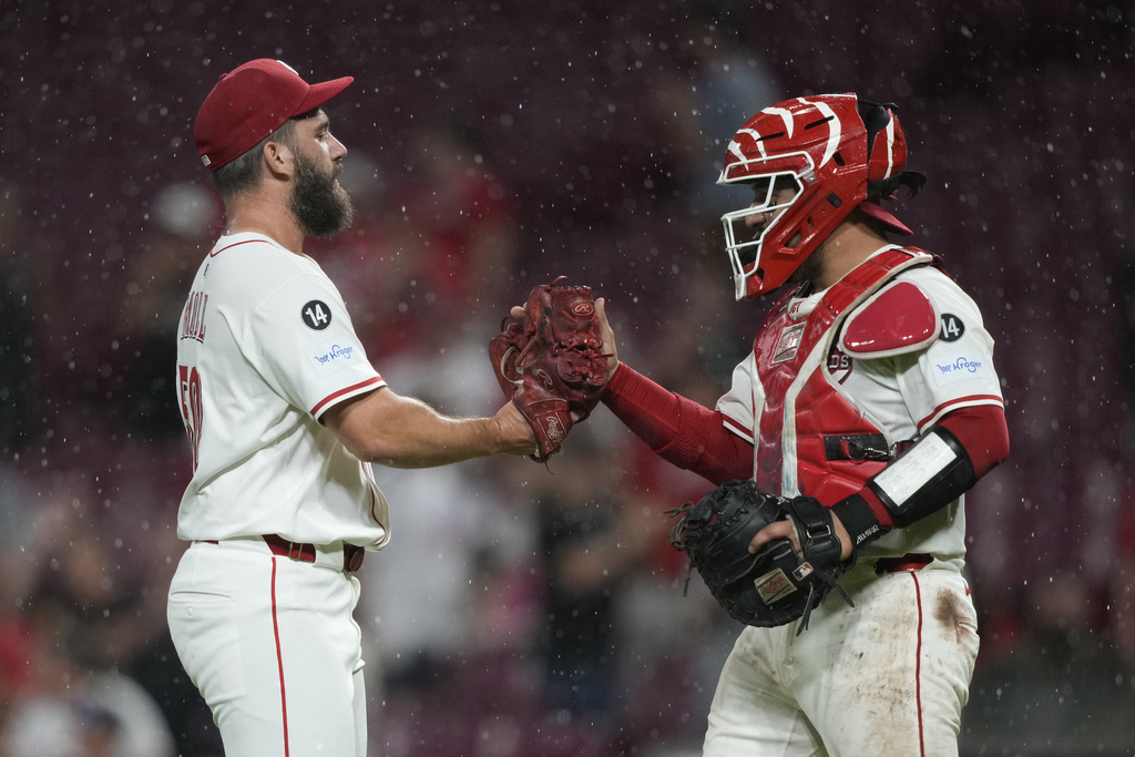 Cincinnati Reds pitcher Sam Moll, left, and Cincinnati Reds catcher Jose Trevino celebrate after winning a baseball game against the Philadelphia Phillies Tuesday, Aug. 12, 2025, in Cincinnati. (AP Photo/Carolyn Kaster)