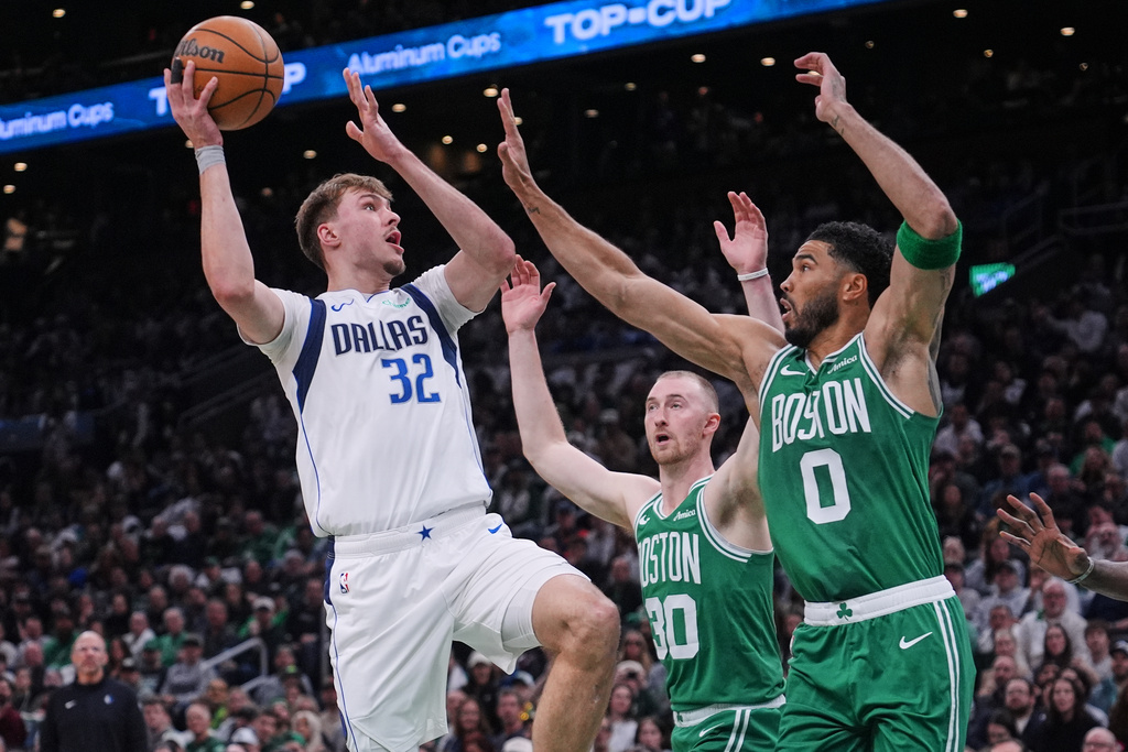 Dallas Mavericks forward Cooper Flagg (32) shoots over Boston Celtics' Jayson Tatum (0) and Sam Hauser (30) during the first half of an NBA basketball game, Friday, March 6, 2026, in Boston. (AP Photo/Charles Krupa)