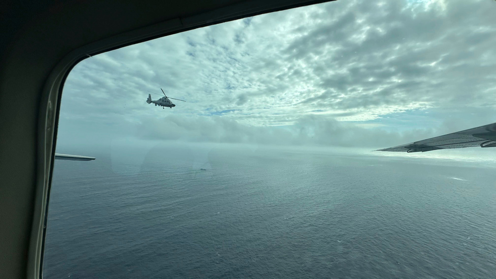 FILE - A Chinese military helicopter flies close to a Philippine Bureau of Fisheries and Aquatic (BFAR) aircraft above Scarborough shoal on Feb. 18, 2025. (AP Photo/Joeal Calupitan, File)