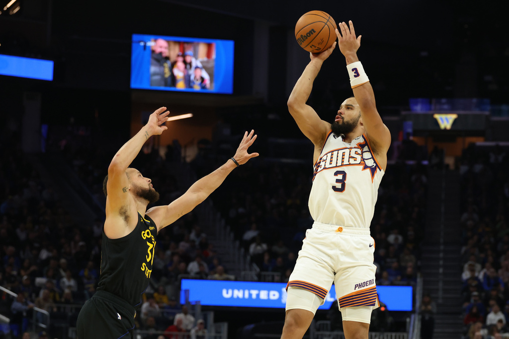 Phoenix Suns forward Dillon Brooks (3) looks to shoot against Golden State Warriors guard Stephen Curry, left, during the first half of an NBA basketball game in San Francisco, Saturday, Dec. 20, 2025. (AP Photo/Jed Jacobsohn)