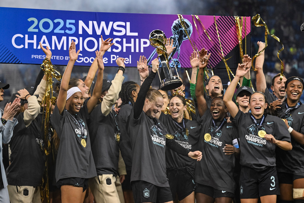 FILE - NJ/NY Gotham FC defender Emily Sonnett, center, lifts the NWSL championship trophy after defeating the Washington Spirit in an NWSL women's championship soccer match Nov. 22, 2025, in San Jose, Calif. (AP Photo/Justine Willard, File)