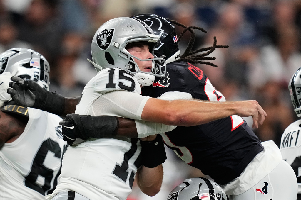 Las Vegas Raiders quarterback Fernando Mendoza (15) is hit by Houston Texans defensive end Jadeveon Clowney (90) during the first half of an NFL preseason football game Thursday, Aug. 20, 2026, in Houston. (AP Photo/Ashley Landis)
