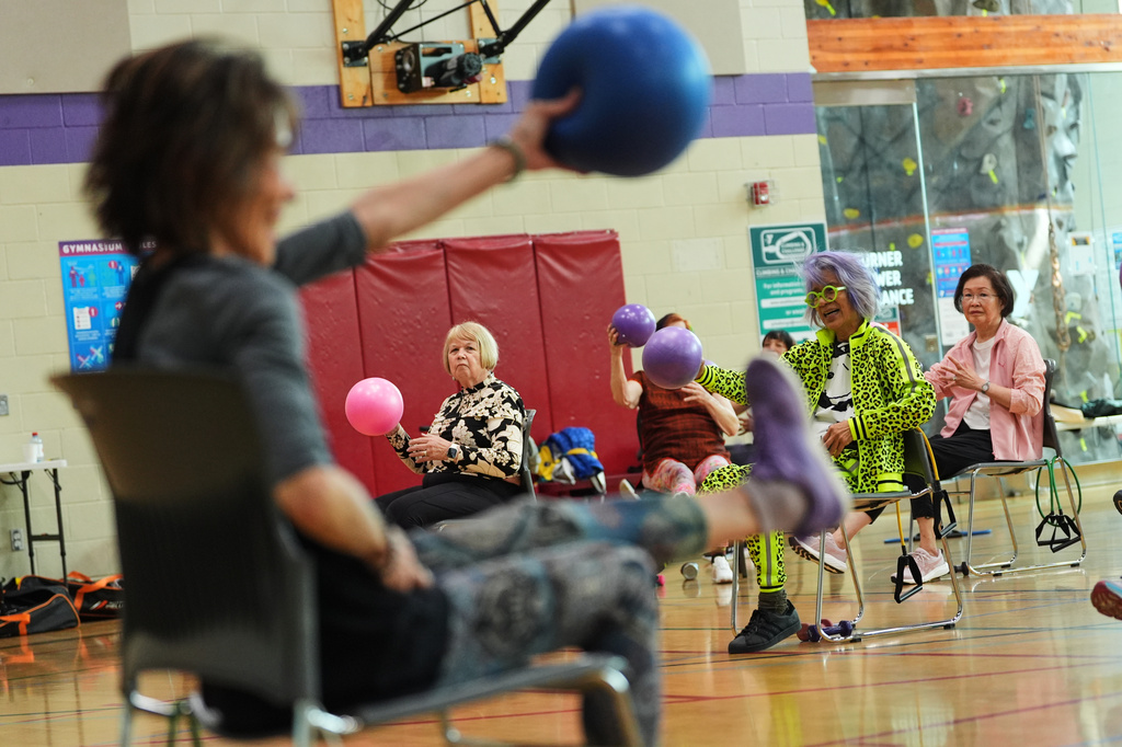 Instructor Bengie Santos, 72, leads a class for older adults, including Lili Bonilla, in a yellow tracksuit, at the Dale Turner Family YMCA, April 30, 2026, in Shoreline, Wash. (AP Photo/Lindsey Wasson)