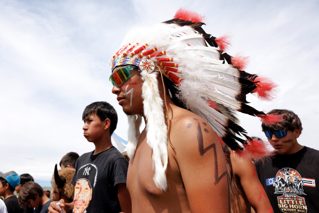 The crowd celebrates after the horse charging event during festivities to commemorate the 150th anniversary of the Battle of the Little Bighorn in Crow Agency, Mont., on Thursday, June 25, 2026. (AP Photo/Tailyr Irvine)