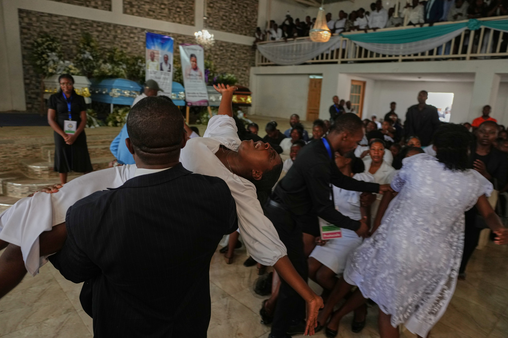 A relative is held as she wails during the funeral service for victims of a gang attack in the Kenscoff neighborhood of Port-au-Prince, Haiti, Wednesday, Sept. 2, 2026. (AP Photo/Odelyn Joseph)