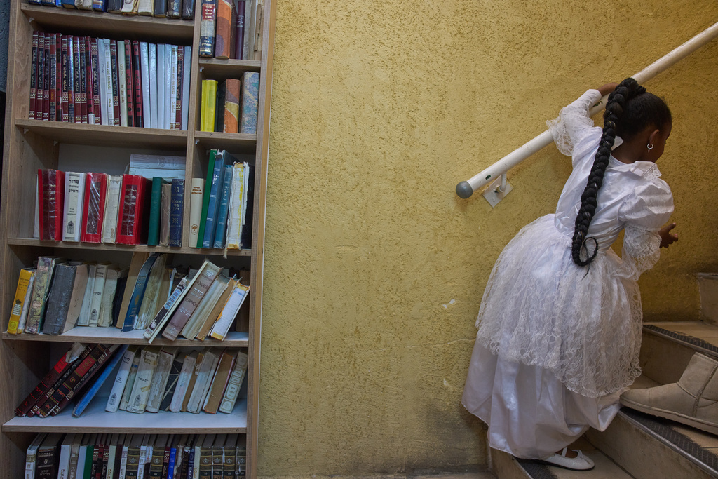 A girl wears a decorative dress during the Jewish festival of Purim inside a bomb shelter synagogue in Hadera, Israel, Monday, March 2, 2026. (AP Photo/Ariel Schalit)