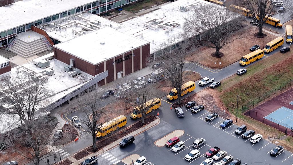 First responders vehicles sit parked near school buses outside North Forsyth High School, in Winston-Salem, N.C., Tuesday Dec. 9, 2025, after a fatal stabbing at the school. (Walt Unks/The Winston-Salem Journal via AP)