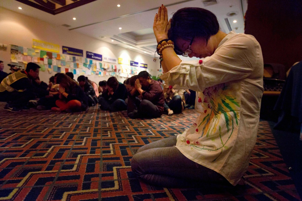 FILE -Relatives of Chinese passengers on board the Malaysia Airlines Flight MH370 pray at a prayer room in Beijing, China, April 4, 2014. (AP Photo/Ng Han Guan, File)