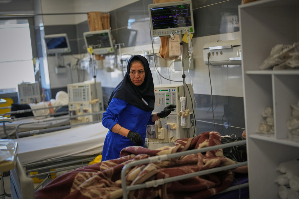 A nurse attends to a patient at Shohadaye Tajrish Hospital in Tehran, Iran, Tuesday, April 7, 2026. (AP Photo/Francisco Seco)